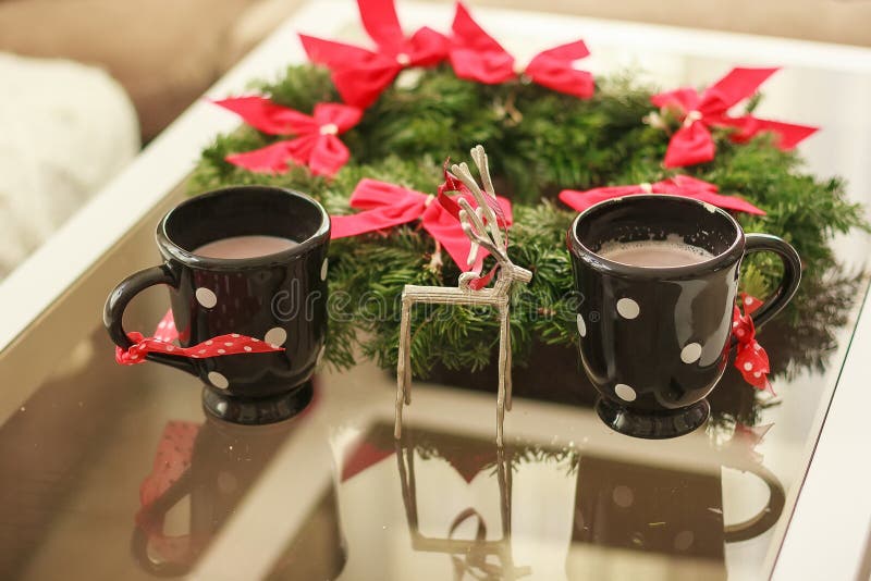 Two cups with a hot drink. Christmas time. concept of family winter holidays. 2 cups of coffee with branch of christmas tree wreath. Two cups with a hot drink. Christmas time. concept of family winter holidays. 2 cups of coffee with branch of christmas tree wreath