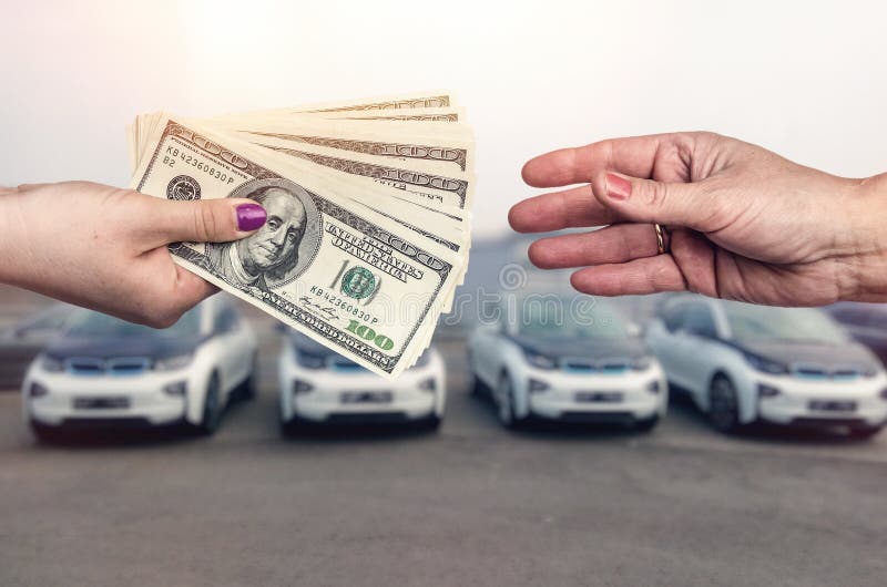 `Buying car ` conception, dollar deal between female hands . `Buying car ` conception, dollar deal between female hands .