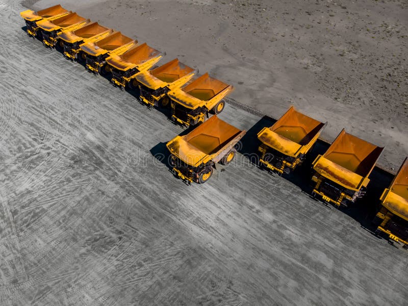 Concept sale of industrial equipment. Parking with big yellow mining truck, bulldozers for coal industry, iron ore and gold. Aerial top view. Concept sale of industrial equipment. Parking with big yellow mining truck, bulldozers for coal industry, iron ore and gold. Aerial top view.