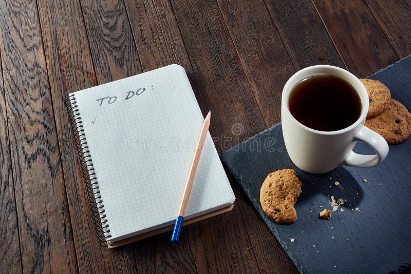 Kop thee met koekjes, werkboek en een potlood op een houten achtergrond, hoogste mening royalty-vrije stock fotografie Kop thee met koekjes, werkboek en een potlood op een houten achtergrond, hoogste mening royalty-vrije stock fotografie