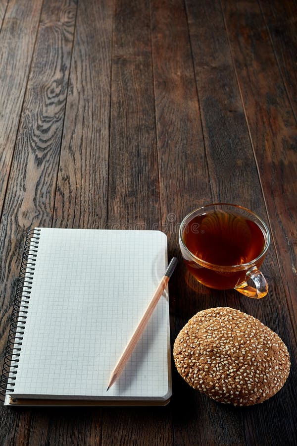 Kop thee met koekjes, werkboek en een potlood op een houten achtergrond, hoogste verticale mening, royalty-vrije stock foto's Kop thee met koekjes, werkboek en een potlood op een houten achtergrond, hoogste verticale mening, royalty-vrije stock foto's