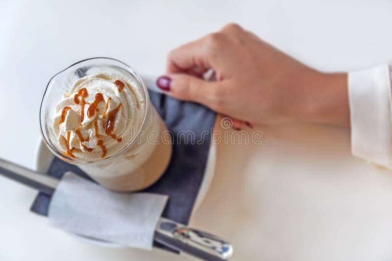 Kop van een verse karamel latte met slagroom op lijst in koffiewinkel stock afbeeldingen Kop van een verse karamel latte met slagroom op lijst in koffiewinkel stock afbeeldingen