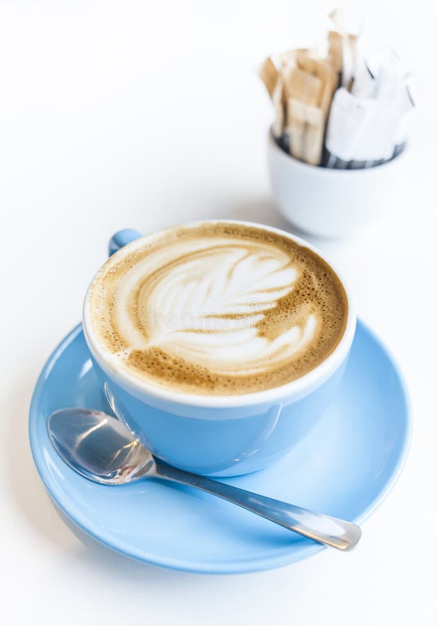 Kop van lattekunst op een cappuccinokoffie in blauwe kop