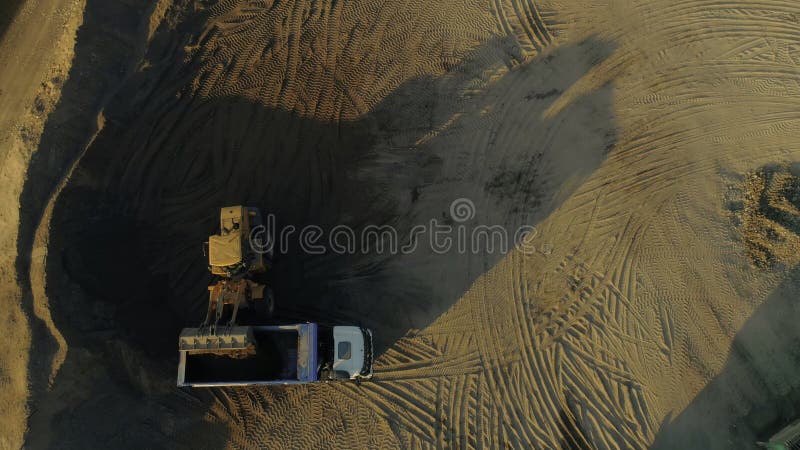 Koparka usuwająca piasek do wozu samowyładowczego. scena. widok górny załadunku piasku koparki do samochodu ciężarowego. konstrukc fotografia royalty free