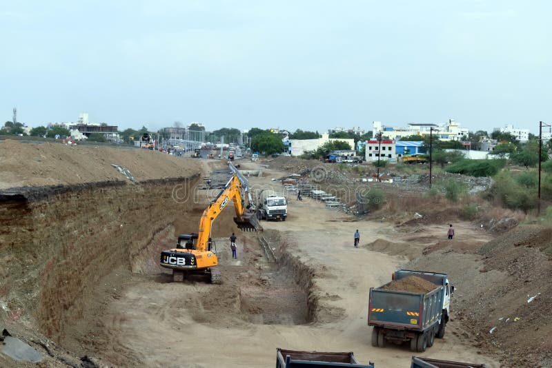 excavator and dumper truck working on new asphalt road construction in India. excavator and dumper truck working on new asphalt road construction in India.