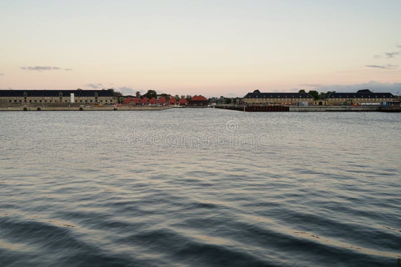 Copenhagen harbor buildings, view from `Ofelia plads` before sunset, water in front. Copenhagen harbor buildings, view from `Ofelia plads` before sunset, water in front