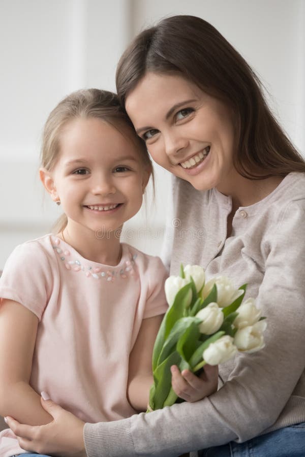 Kopf-Foto-Portrait Mutter und kleine Tochter mit Blumen vertikal stockfoto