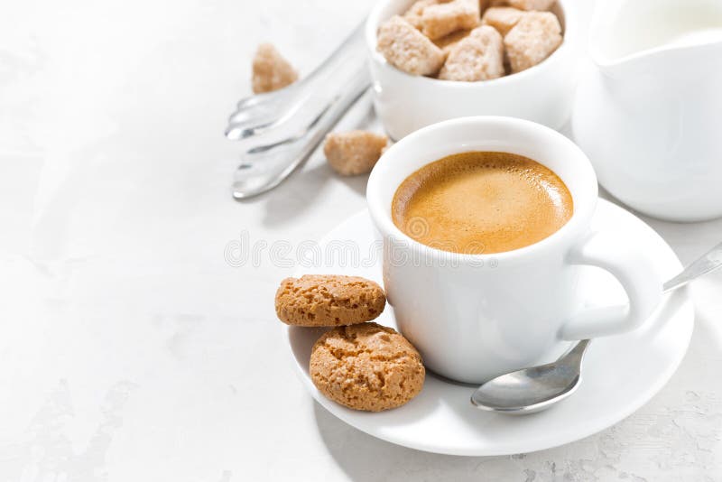 Kopp av espresso- och mandelkakor på en vit tabell som är horisontal royaltyfri foto Kopp av espresso- och mandelkakor på en vit tabell som är horisontal royaltyfri foto