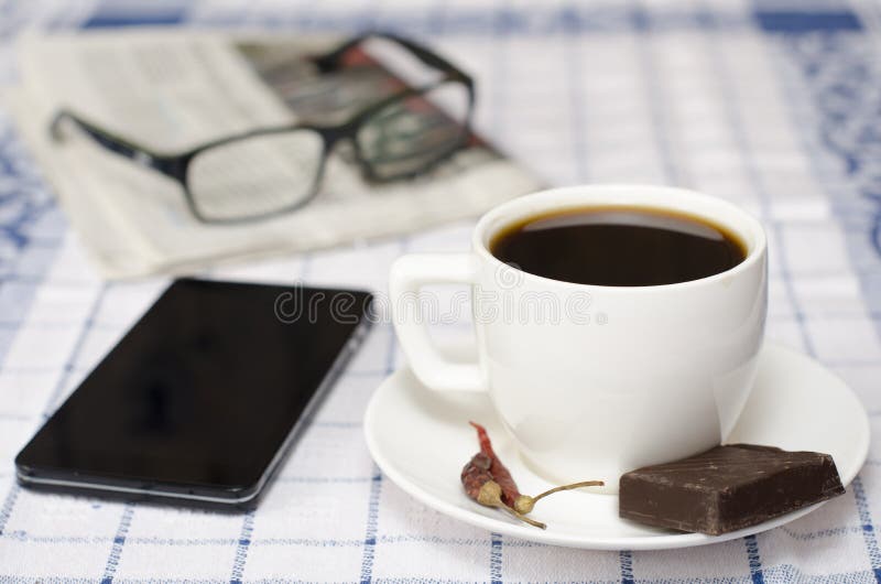 Kopp kaffe med den telefonexponeringsglas och tidningen fotografering för bildbyråer Kopp kaffe med den telefonexponeringsglas och tidningen fotografering för bildbyråer