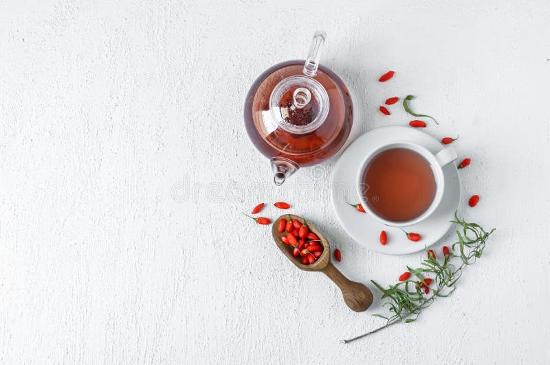 Kopp örtguji berry-te med färska gojibär. Koppar av örttågstam med färska gojibär på rustika