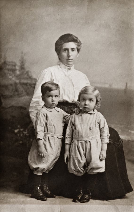 Early 1990s sepia-toned photograph of a mother with her fraternal twins. Early 1990s sepia-toned photograph of a mother with her fraternal twins.