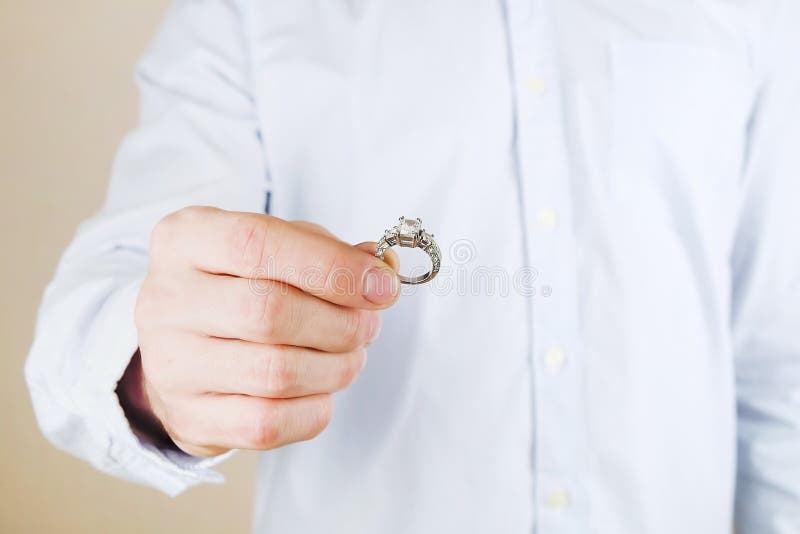Kopplings-/förbindelse-/bröllopförslagplats Stäng sig upp av mannen som räcker den dyra guld- platinadiamantcirkeln till hans bru arkivbild Kopplings-/förbindelse-/bröllopförslagplats Stäng sig upp av mannen som räcker den dyra guld- platinadiamantcirkeln till hans bru arkivbild