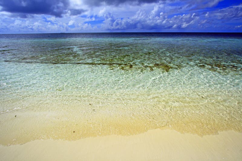 Cloudy sky at dreamy coral sea beach at eriyadu island at north male atoll in maldives. Cloudy sky at dreamy coral sea beach at eriyadu island at north male atoll in maldives