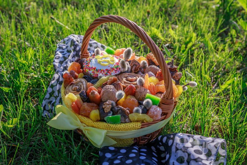 Korb mit Ostern-Kuchen, -Trockenfr?chten und -n?ssen auf dem gr?nen Gras im Garten stockfotografie Korb mit Ostern-Kuchen, -Trockenfr?chten und -n?ssen auf dem gr?nen Gras im Garten stockfotografie