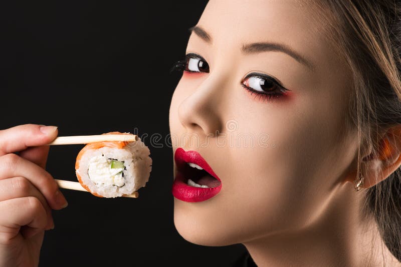 Koreaans mooi tienermeisje die met heldere make-up een broodje eten stock foto's Koreaans mooi tienermeisje die met heldere make-up een broodje eten stock foto's
