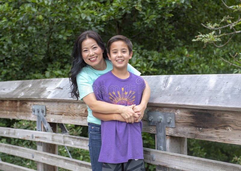 Koreaanse moeder en haar Amerasian-zoon het stellen op een houten brug in Washington Park Arboretum, Seattle, Washington stock afbeeldingen Koreaanse moeder en haar Amerasian-zoon het stellen op een houten brug in Washington Park Arboretum, Seattle, Washington stock afbeeldingen