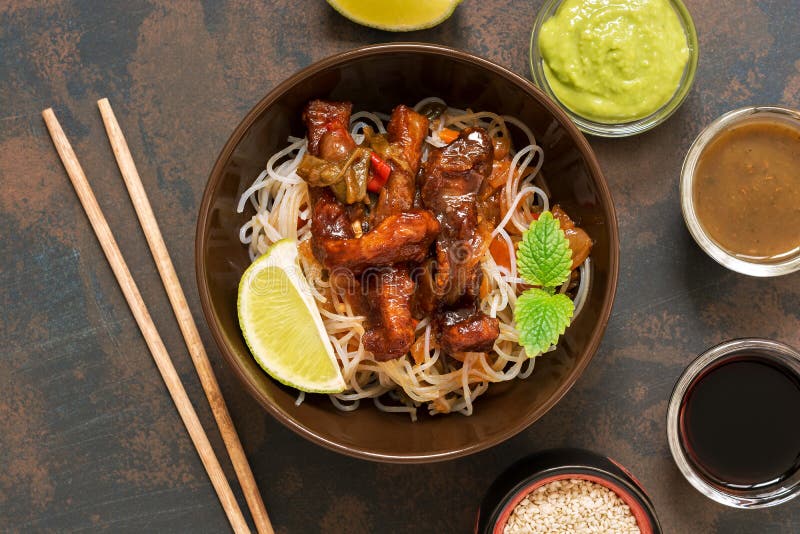 Korean dish of noodles with fried meat and vegetables. Asian food, on an old rusty background. View from above. royalty free stock photo Korean dish of noodles with fried meat and vegetables. Asian food, on an old rusty background. View from above. royalty free stock photo