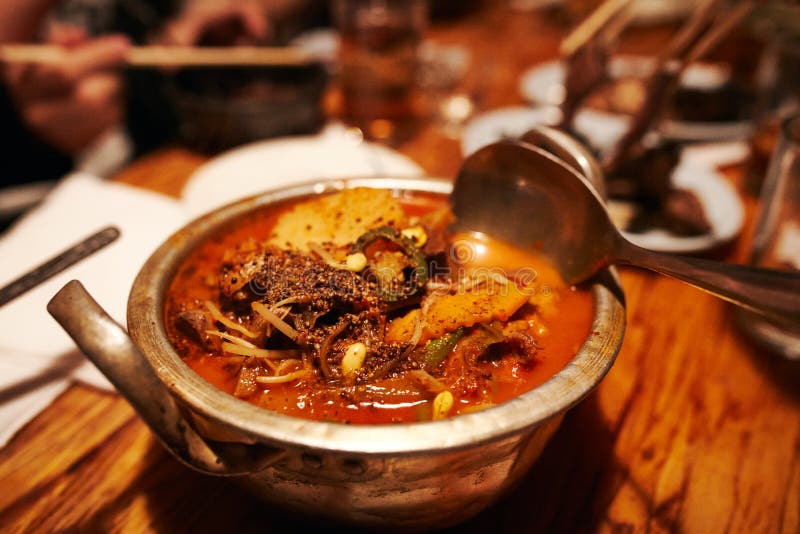 Korean Style Spicy Beef Soup with Herbs in Tin Pot Stock Photo Image
