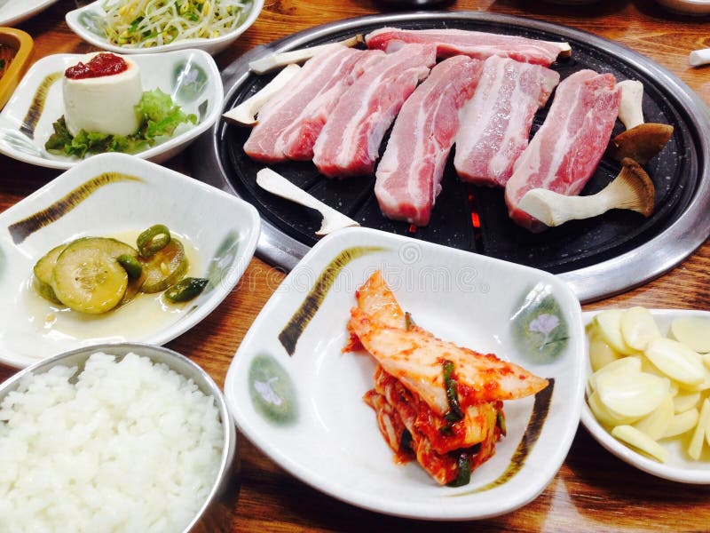 Koreansk mat, BBQ, grillade griskött i den koreanska restaurangen, Sydkorea royaltyfri bild Koreansk mat, BBQ, grillade griskött i den koreanska restaurangen, Sydkorea royaltyfri bild