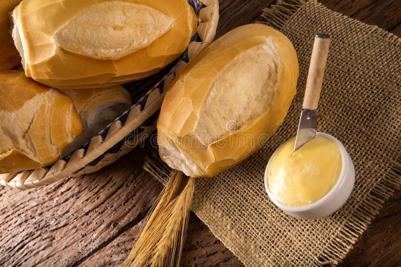 Korg av `-franskbröd`, traditionellt brasilianskt bröd med smör på wood bakgrund royaltyfri foto Korg av `-franskbröd`, traditionellt brasilianskt bröd med smör på wood bakgrund royaltyfri foto