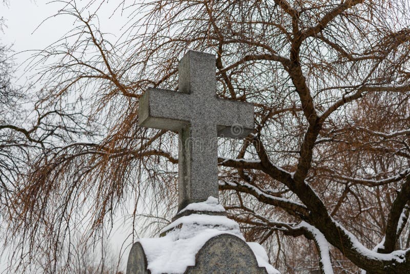 Kors överst av en gravsten på en kyrkogård i vinter med snö royaltyfri foto Kors överst av en gravsten på en kyrkogård i vinter med snö royaltyfri foto