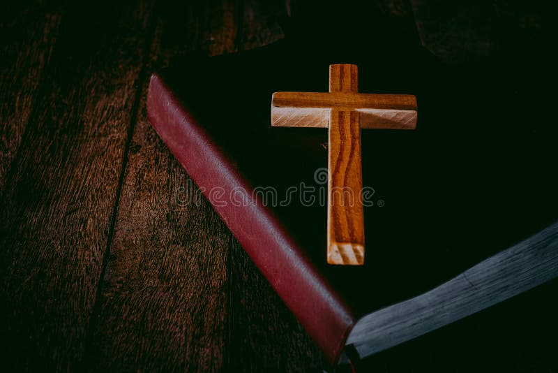The cross is placed on the Bible. The concept of praying from the Lord with the power and power of holiness that brings luck and expresses forgiveness through the power of religion, faith. The cross is placed on the Bible. The concept of praying from the Lord with the power and power of holiness that brings luck and expresses forgiveness through the power of religion, faith.