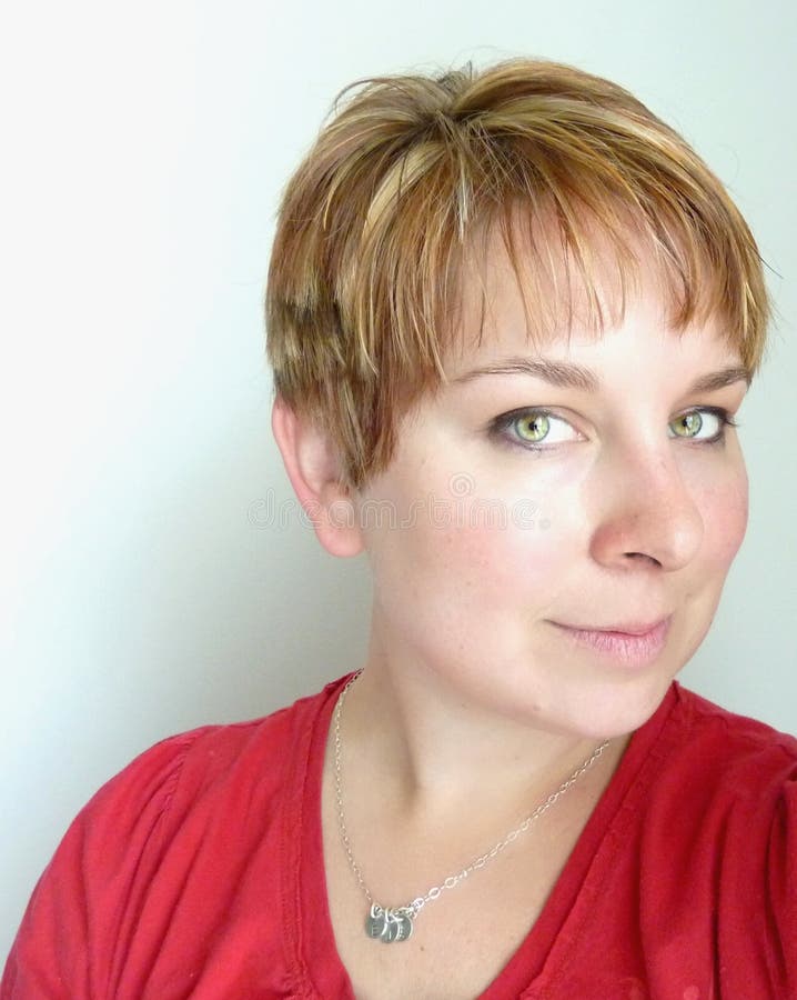 A green eyed woman shows off her highlighted short hair style. A green eyed woman shows off her highlighted short hair style.
