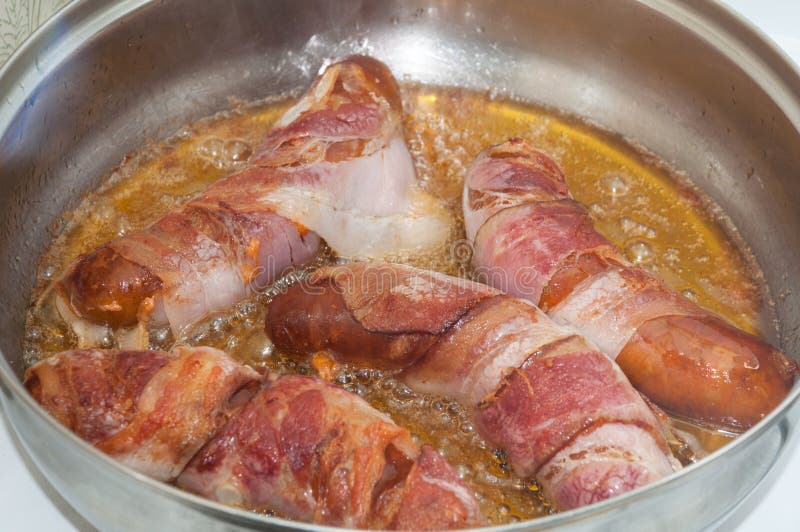 KORVAR MED RÖKT BACON I DJUP VARM OLJA royaltyfri fotografi KORVAR MED RÖKT BACON I DJUP VARM OLJA royaltyfri fotografi