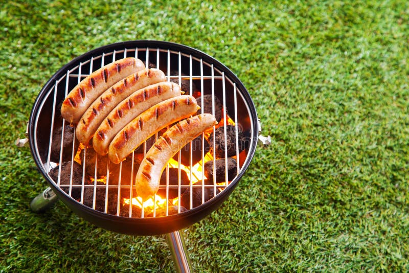 Korvar som grillar på en bärbar grillfest arkivbilder Korvar som grillar på en bärbar grillfest arkivbilder