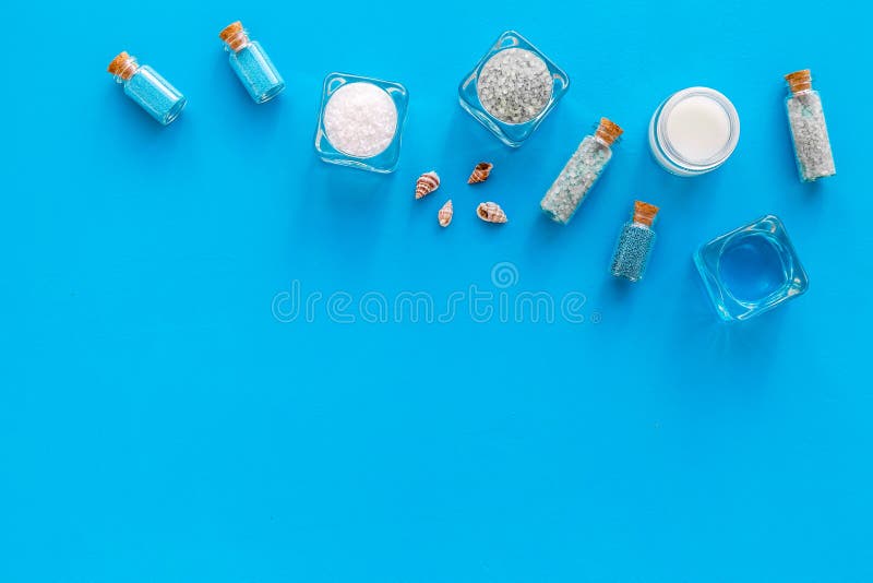 Kosmetikplan des Toten Meers Seesalz in den Flaschen und in den Schüsseln nahe kleinen Oberteilen auf blauem Draufsicht-Kopienrau lizenzfreie stockbilder Kosmetikplan des Toten Meers Seesalz in den Flaschen und in den Schüsseln nahe kleinen Oberteilen auf blauem Draufsicht-Kopienrau lizenzfreie stockbilder