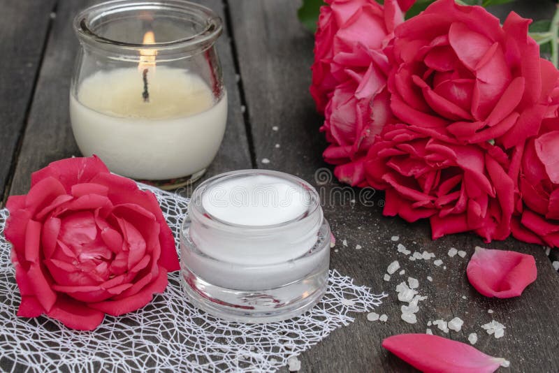 Kosmetische Creme und Rosen mit den Blumenblättern und einer brennenden Kerze auf dem alten hölzernen Hintergrund stockfotos Kosmetische Creme und Rosen mit den Blumenblättern und einer brennenden Kerze auf dem alten hölzernen Hintergrund stockfotos
