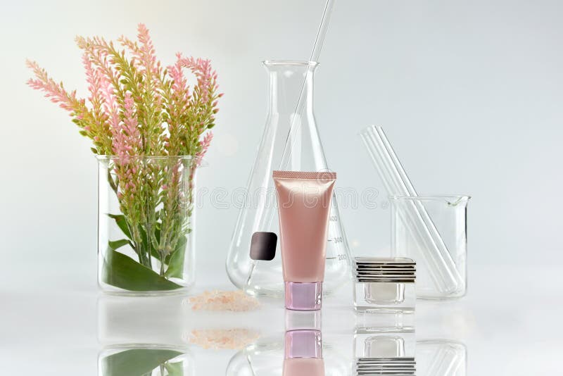 Kosmetische Flaschenbehälter mit grünen Kräuterblättern und wissenschaftlichen Glaswaren, leeres Aufkleberpaket für einbrennendes lizenzfreies stockbild Kosmetische Flaschenbehälter mit grünen Kräuterblättern und wissenschaftlichen Glaswaren, leeres Aufkleberpaket für einbrennendes lizenzfreies stockbild