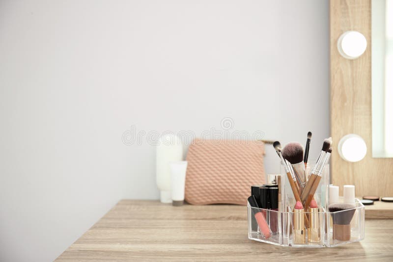 Kosmetische Produkte des Makes-up mit Werkzeugen im Organisator auf Frisierkommode