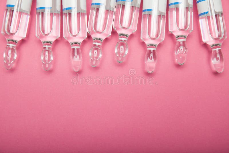 Kosmetische voorbereidingen in ampullen op een roze achtergrond De ruimte van het exemplaar stock fotografie Kosmetische voorbereidingen in ampullen op een roze achtergrond De ruimte van het exemplaar stock fotografie