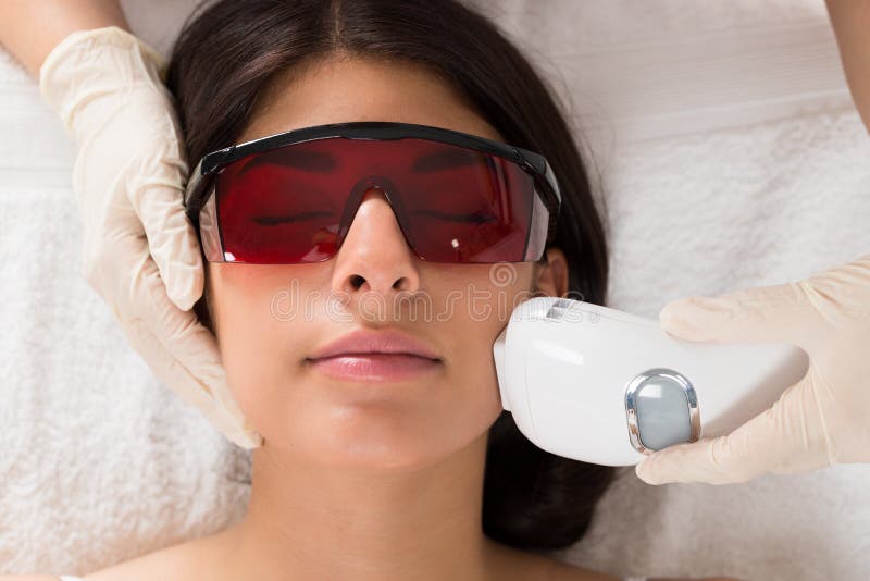 Kosmetolog som ger epilationlaser-behandling royaltyfri foto Kosmetolog som ger epilationlaser-behandling royaltyfri foto