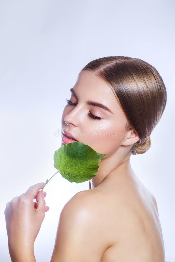 kosmetyk organicznie Piękny kobiety twarzy portret z zielonym liściem, pojęciem dla skóry opieki lub organicznie kosmetykami, obrazy royalty free kosmetyk organicznie Piękny kobiety twarzy portret z zielonym liściem, pojęciem dla skóry opieki lub organicznie kosmetykami, obrazy royalty free