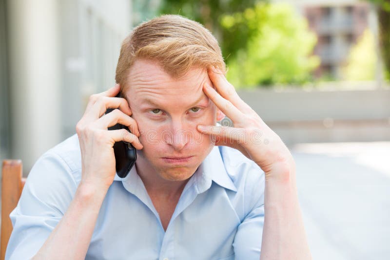 Closeup portrait, young man annoyed, frustrated, off by someone talking on his mobile phone, bad news, outdoors outside background. Long wait times, horrible conversations concept. Closeup portrait, young man annoyed, frustrated, off by someone talking on his mobile phone, bad news, outdoors outside background. Long wait times, horrible conversations concept