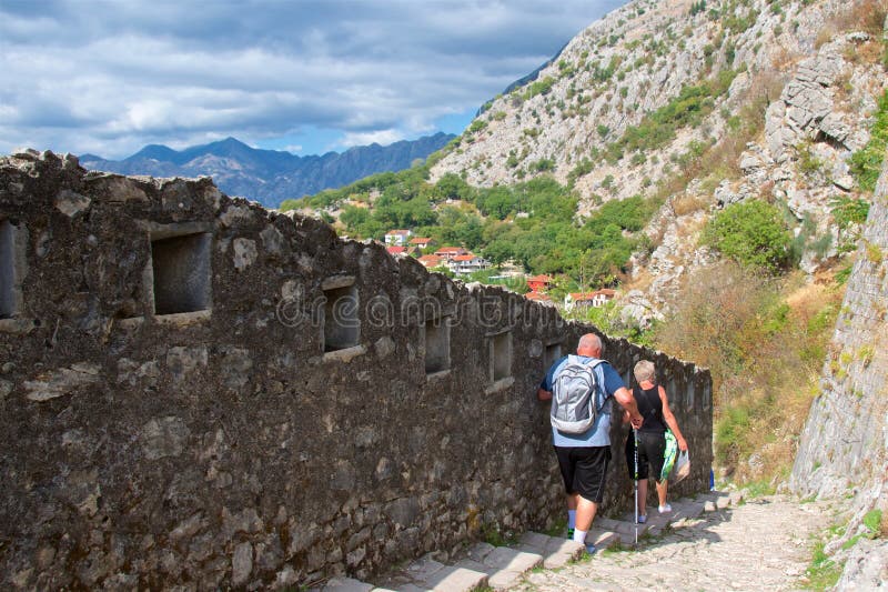 Kotor, Черногория - октябрь 2017: Туристы след вдоль стен городища в городке Kotor старом, Черногории стоковое фото rf Kotor, Черногория - октябрь 2017: Туристы след вдоль стен городища в городке Kotor старом, Черногории стоковое фото rf