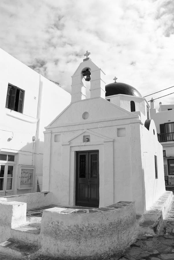 Kościelny budynek w Mykonos, Grecja Kaplica z dzwonkowy wierza i czerwoną kopułą Biała kościelna architektura na chmurnym niebie obrazy stock Kościelny budynek w Mykonos, Grecja Kaplica z dzwonkowy wierza i czerwoną kopułą Biała kościelna architektura na chmurnym niebie obrazy stock