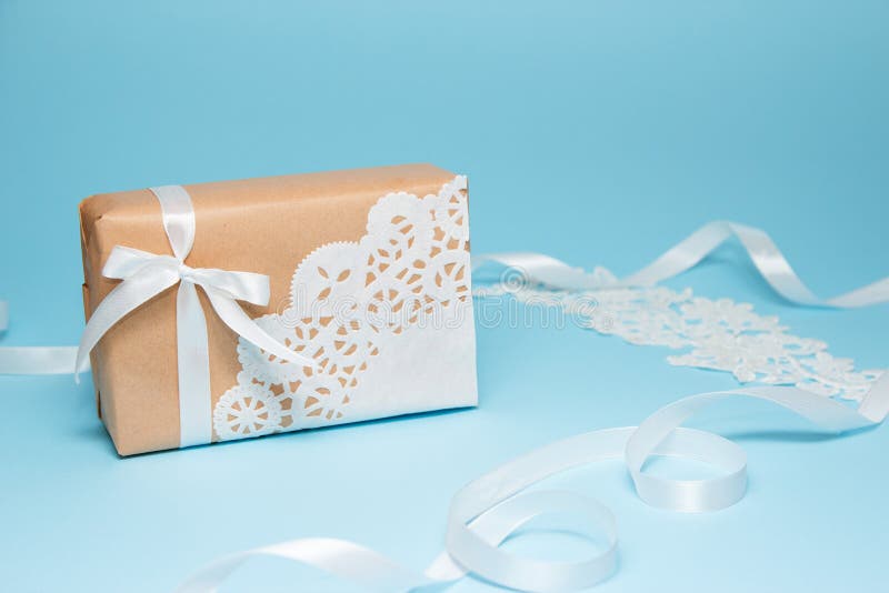 Kraftpapier-document gift met een kantservet wordt verfraaid op een blauwe document achtergrond die De groetkaart van de vakantie royalty-vrije stock fotografie Kraftpapier-document gift met een kantservet wordt verfraaid op een blauwe document achtergrond die De groetkaart van de vakantie royalty-vrije stock fotografie