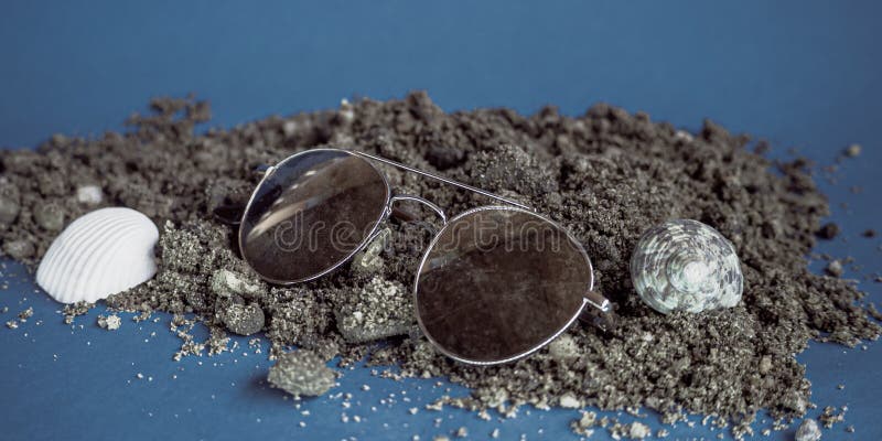 05092022. kragujevac. scoici de pe plajă și ochelari de soare pe fond albastru închis stock images