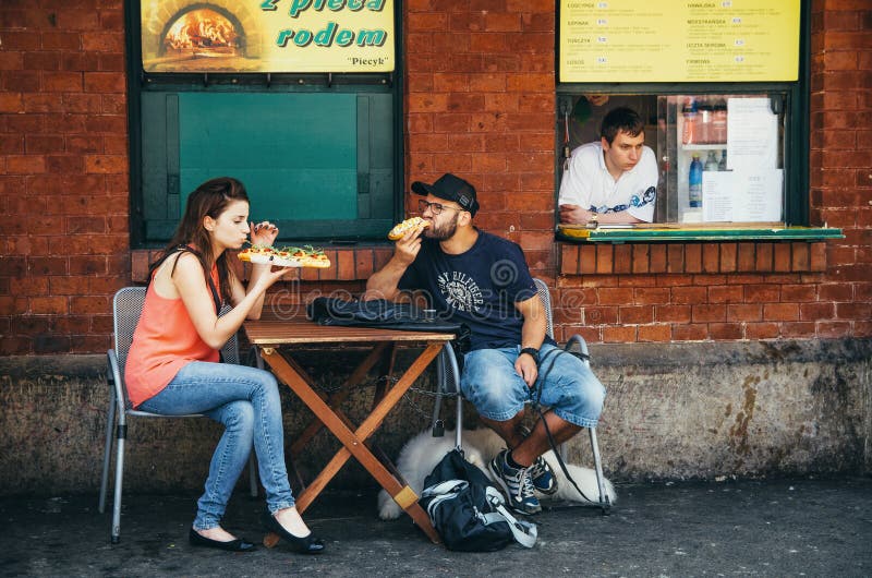 KRAKAU, POLEN - JUNI 26, 2015: Paar, verkopers en poetsmiddelfastfood - zapekanka op Nowy-Vierkant stock foto's KRAKAU, POLEN - JUNI 26, 2015: Paar, verkopers en poetsmiddelfastfood - zapekanka op Nowy-Vierkant stock foto's