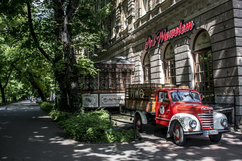 KRAKAU, POLEN 10 05 2015: Roter LKW mit den Bierfässern, zum des Touristenbarrestaurants unter wawel Kathedrale anzuziehen lizenzfreie stockfotografie KRAKAU, POLEN 10 05 2015: Roter LKW mit den Bierfässern, zum des Touristenbarrestaurants unter wawel Kathedrale anzuziehen lizenzfreie stockfotografie