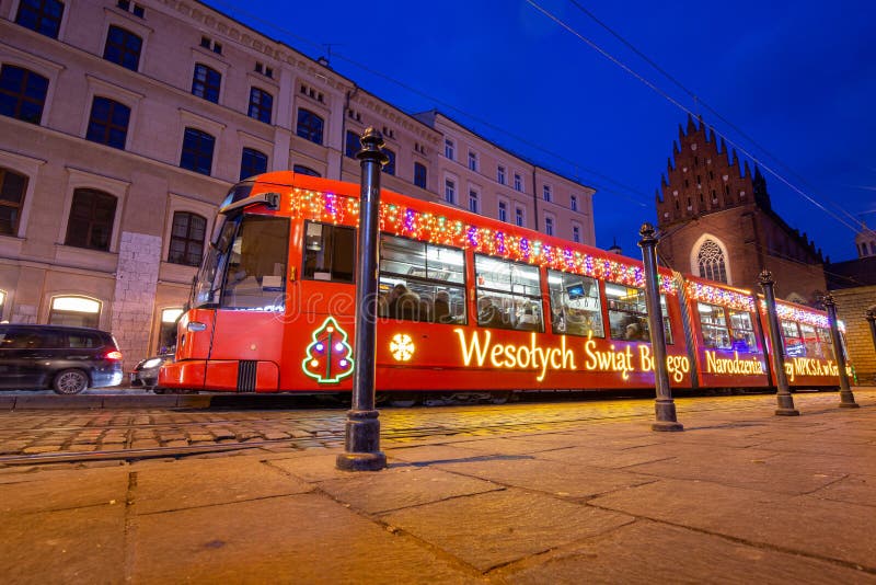 KRAKOW, POLSKA - 8 grudnia 2019 r.: Bożego Narodzenia ozdobiona tramwajem na ulicy wieczornej zdjęcia royalty free KRAKOW, POLSKA - 8 grudnia 2019 r.: Bożego Narodzenia ozdobiona tramwajem na ulicy wieczornej zdjęcia royalty free