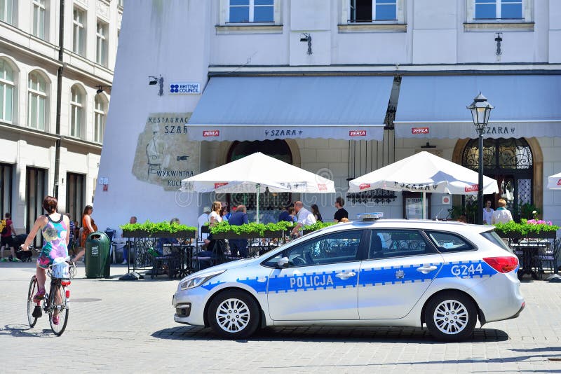 KRAKÓW, POLONIA - JUNIO DE 2017: Coche policía de la patrulla en la Kraków Squ fotografía de archivo KRAKÓW, POLONIA - JUNIO DE 2017: Coche policía de la patrulla en la Kraków Squ fotografía de archivo