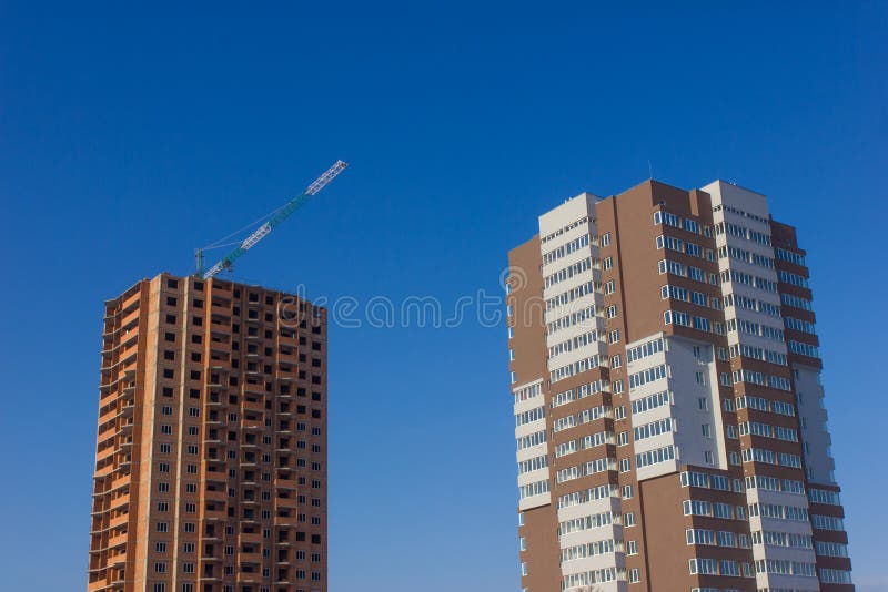Kran und Hochbausite gegen blauen Himmel stockfotografie Kran und Hochbausite gegen blauen Himmel stockfotografie