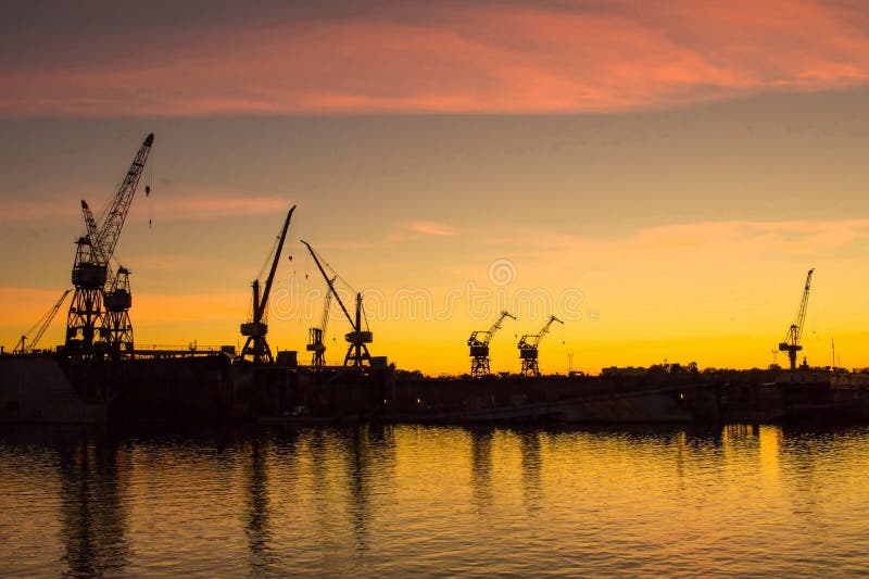 Kranen bij zonsondergang in haven van Riga royalty-vrije stock afbeelding Kranen bij zonsondergang in haven van Riga royalty-vrije stock afbeelding