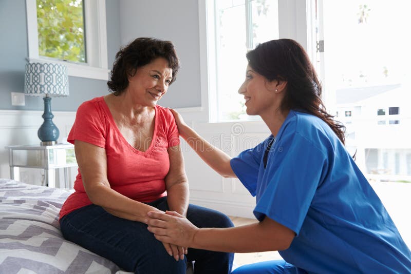 Nurse Making Home Visit To Senior Hispanic Woman. Nurse Making Home Visit To Senior Hispanic Woman