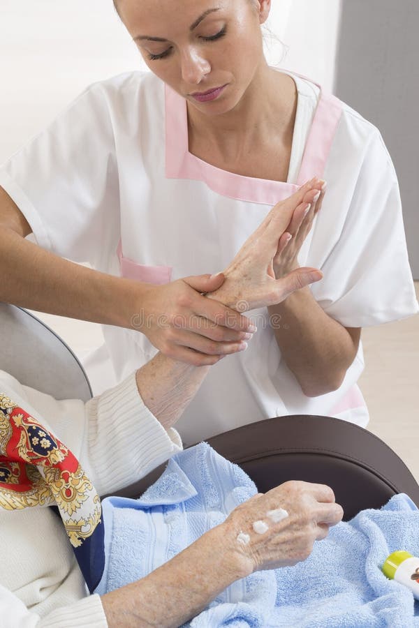 Krankenschwester oder Pflegekraft unterstützt eine ältere Frau mit Hautpflege lizenzfreie stockfotografie Krankenschwester oder Pflegekraft unterstützt eine ältere Frau mit Hautpflege lizenzfreie stockfotografie