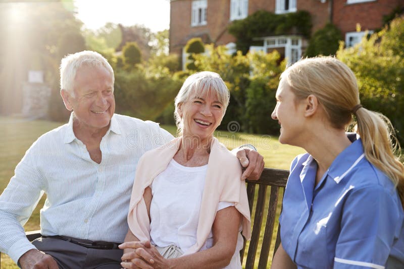 Krankenschwester-Talking To Senior-Paare im Heimpflege-Haus